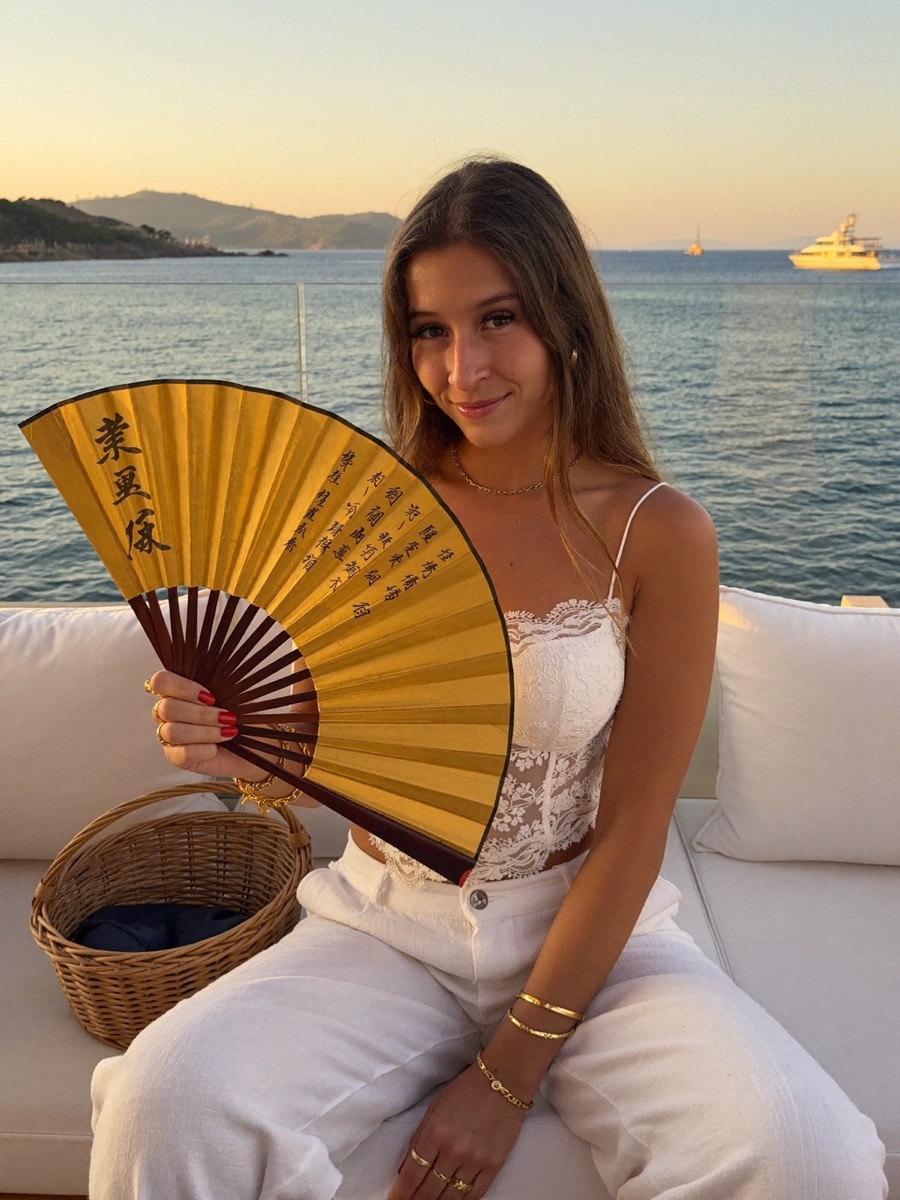 Céline Dite souriante, son éventail doré à la main